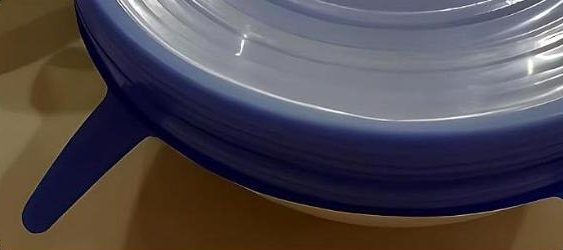Close-up of a lid's pull tab stretched over a bowl rim